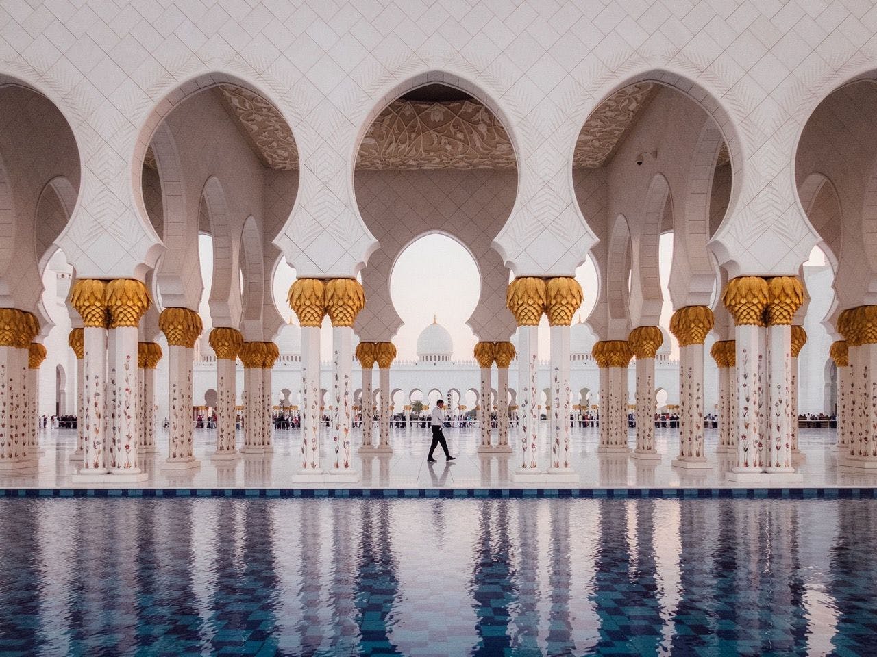 Man walking in Sheikh Zayed Grand Mosque in Abu Dhabi, United Arab Emirates.