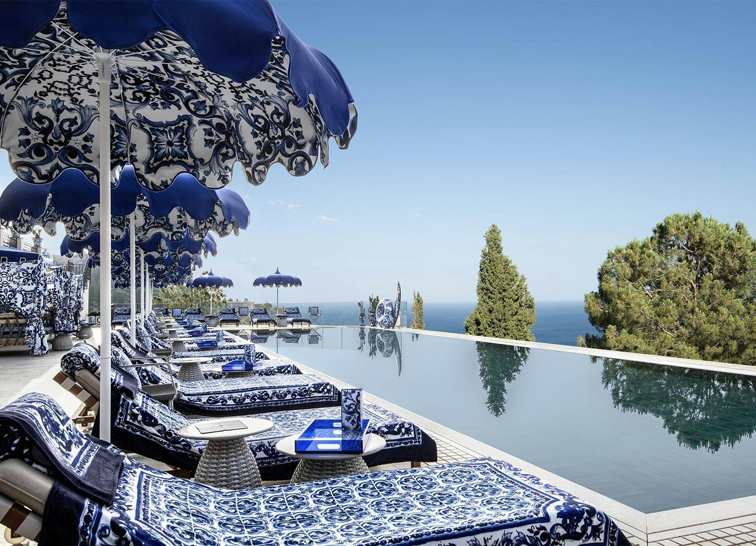 Large infinity pool with Dolce & Gabbana branded sun loungers in Taormina San Domenico resort.