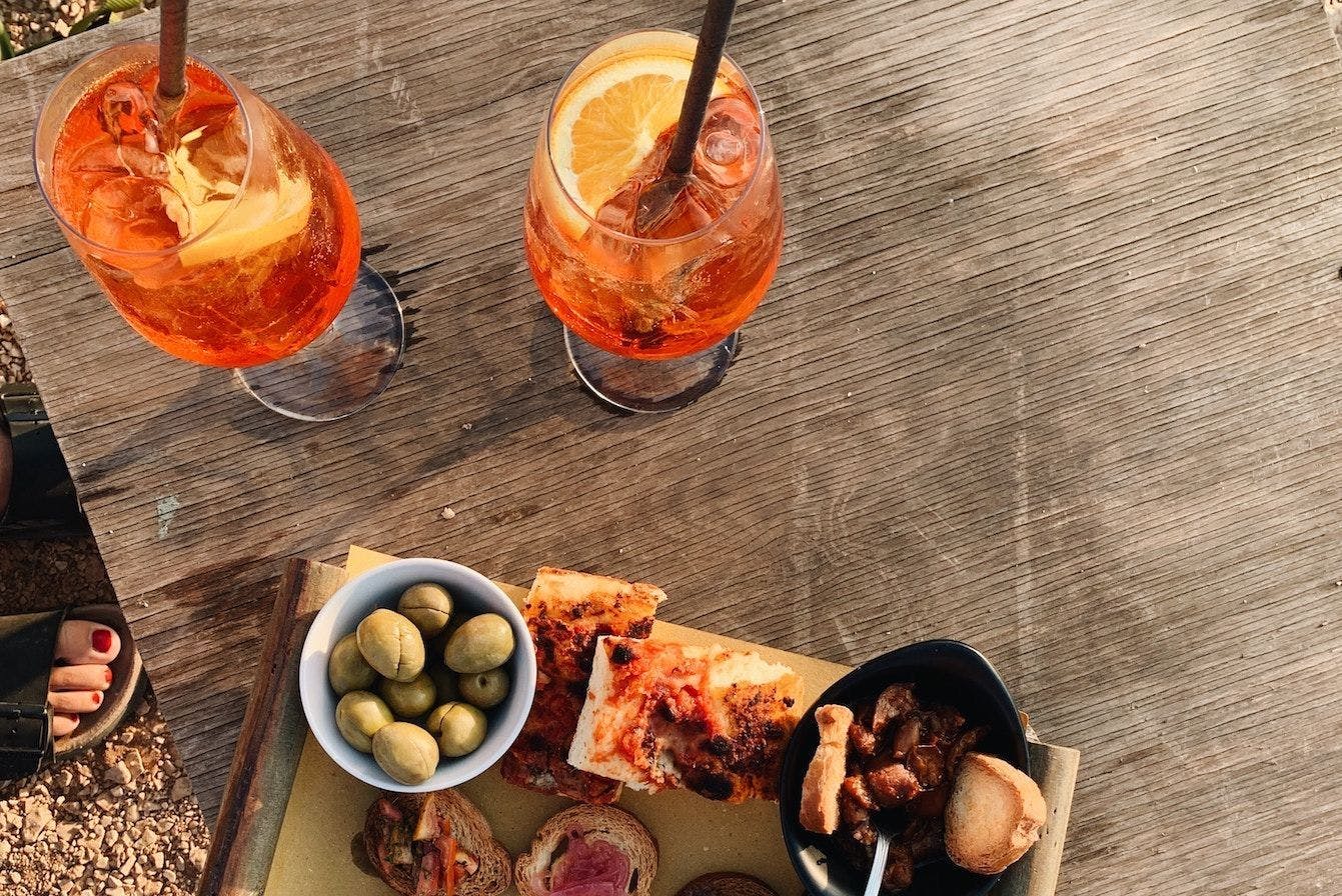 Italian aperitivo with olives and cocktails on a wooden table