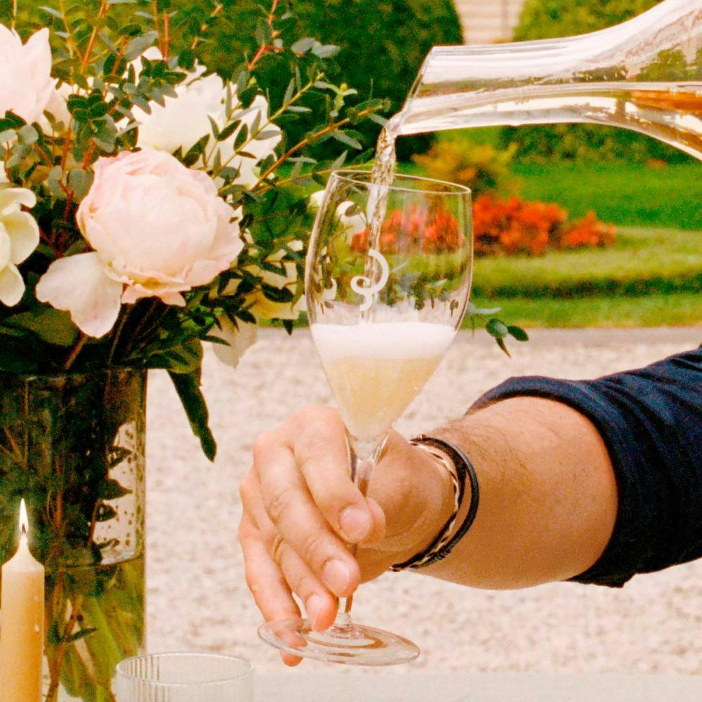 Pouring of champagne into a glass in France.