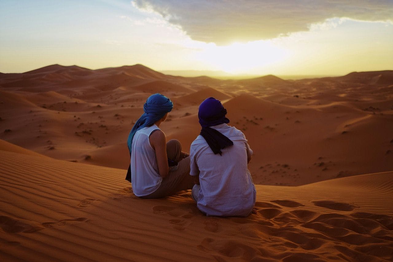 People watching sunset in the desert in Merzouga, Morocco.