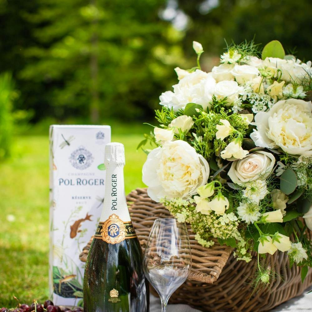 Picnic with grapes and bottle of Pol Roger champagne.