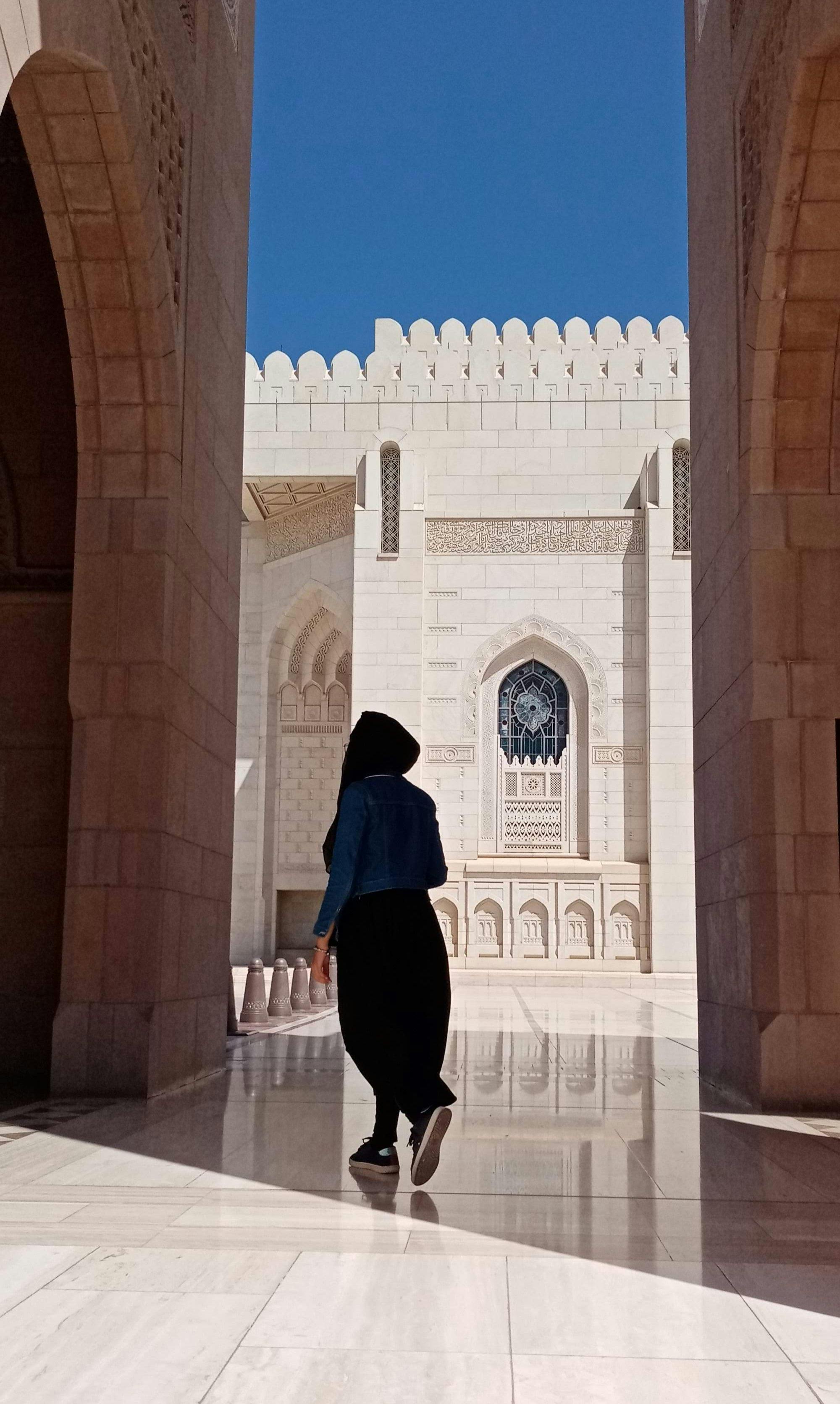 Woman wearing hijab walking in the mosque in Oman.