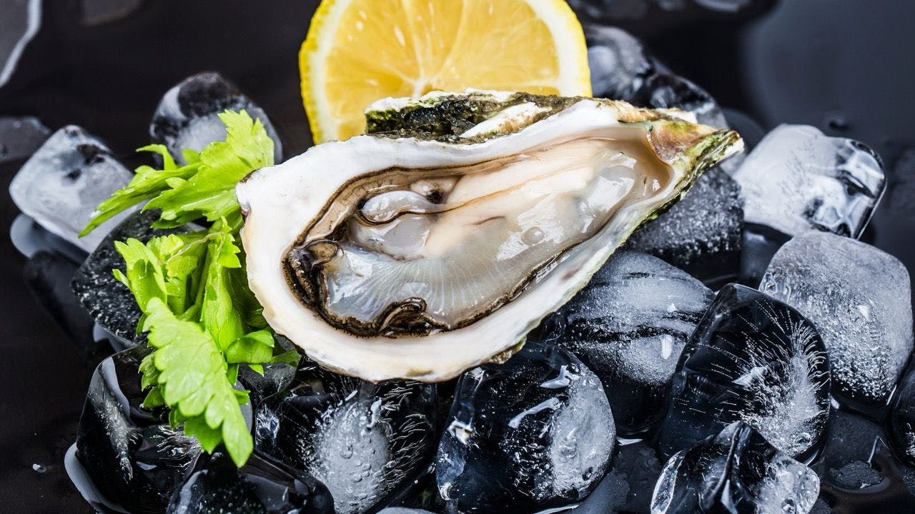 Single oyster with lemon in ice