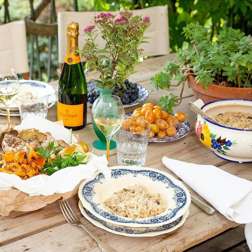 Outdoor dining table with delicious food and Veuve Clicquot champagne.