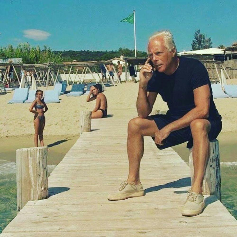 Giorgio Armani sitting on quay in Saint-Tropez beach club Le Club 55