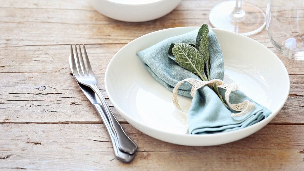 Decorated plate and napkin with leaves placed on a dinner table