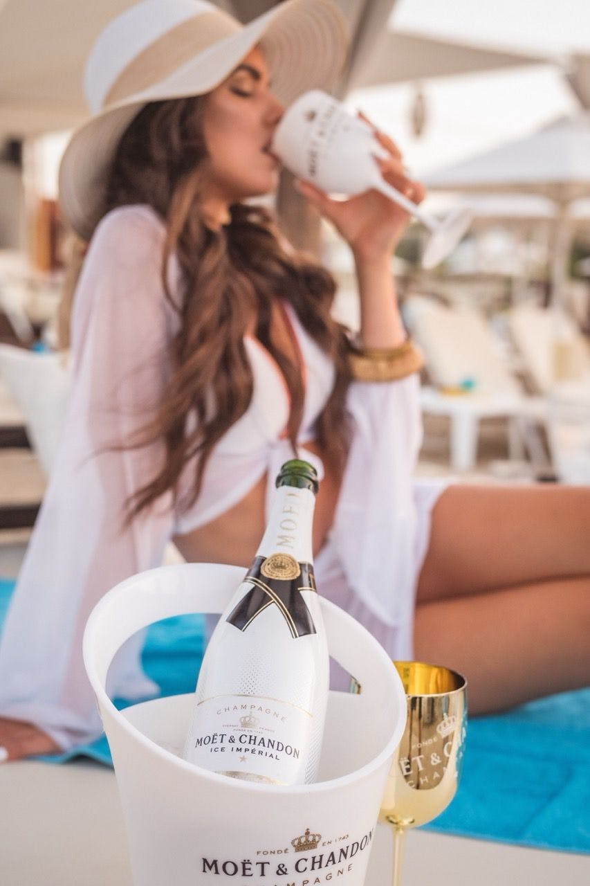 Woman drinking champagne in Saint-Tropez beach club