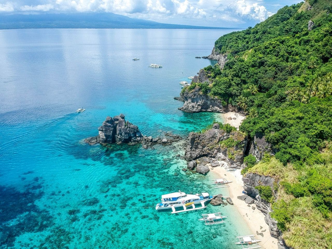 Boats on the coast of Apo Island in Philippines