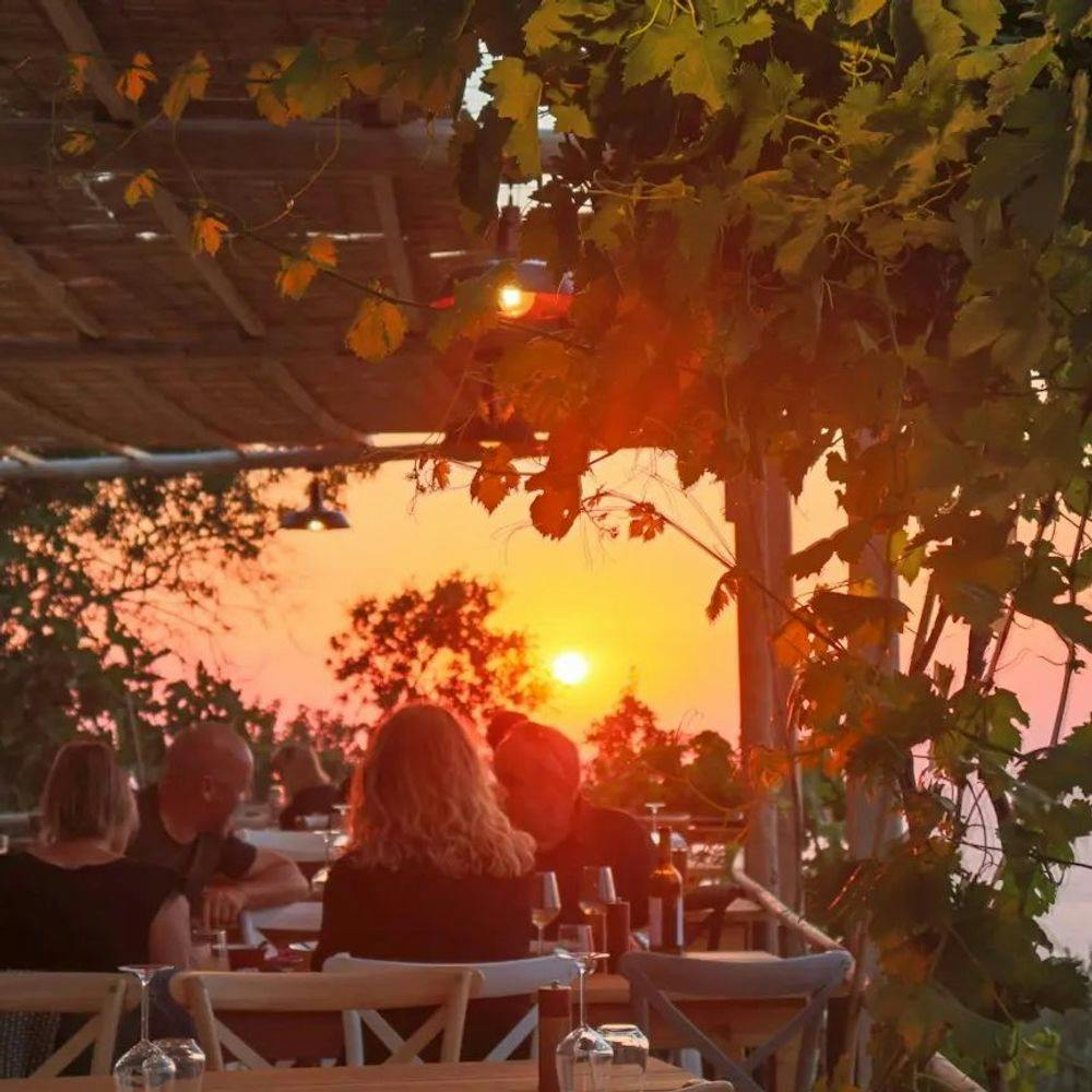 People enjoying sunset and drinking wine