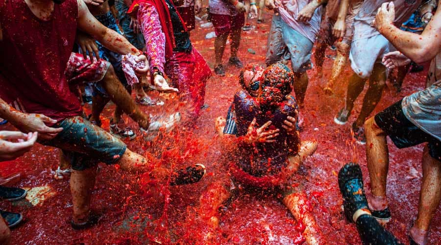 People covered with tomatoes in La Tomatina festival in Spain.