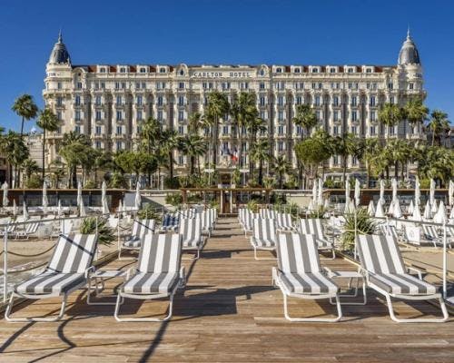 Hotel Carlton Cannes building with sunbeds in Cannes.