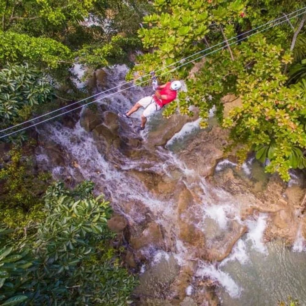 Man zip lining in Dunn's River Falls in Jamaica.