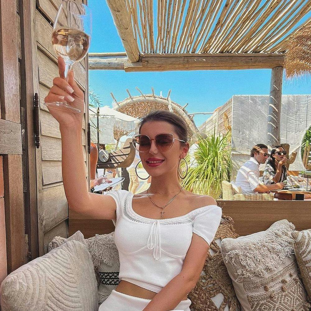 Woman holding a wine glass in Saint-Tropez beach club Verde Beach