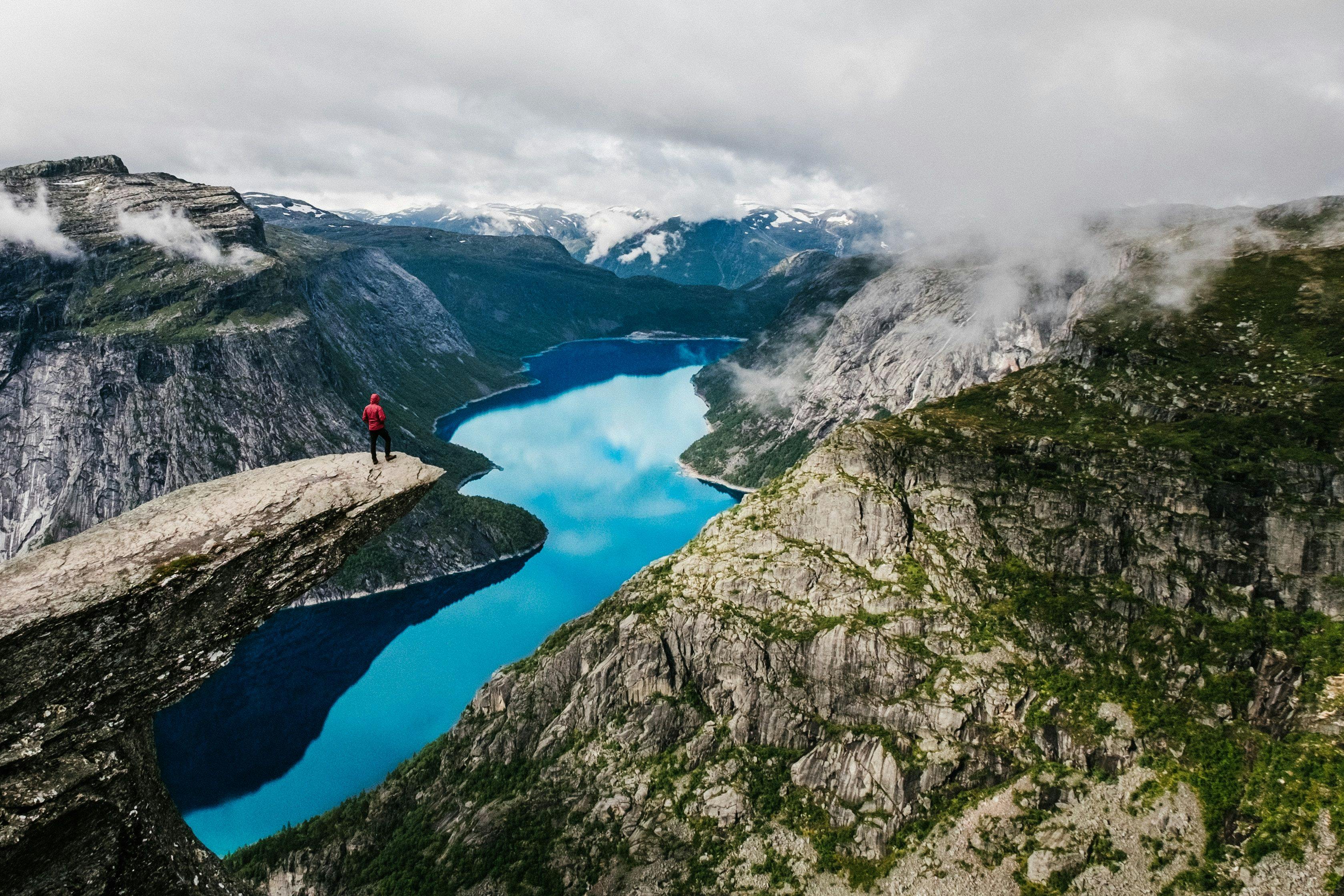 Man standing on the cliff of Trolltunga in Norway.