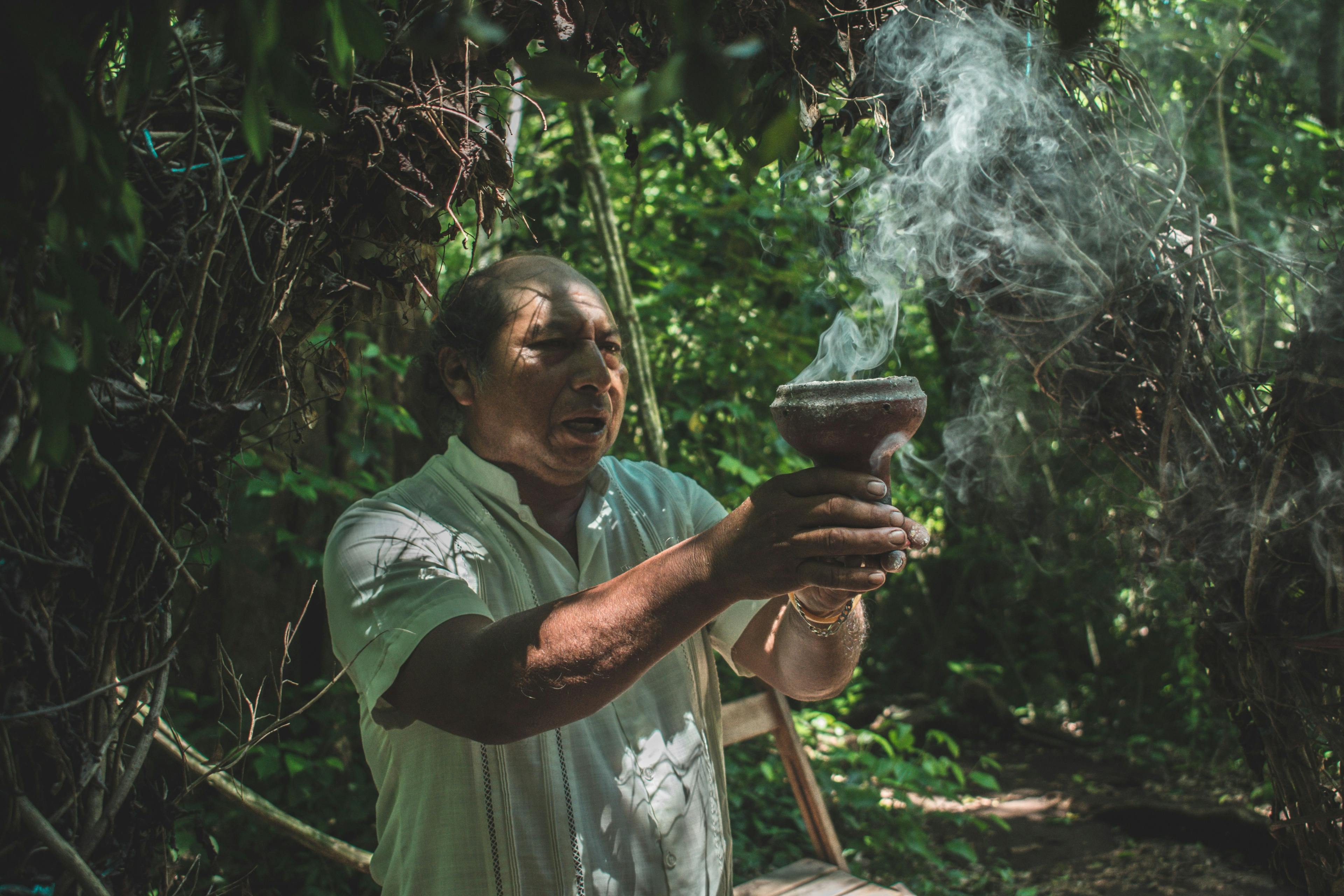 Man with a smoking pot during Mayan ceremony in Tulum