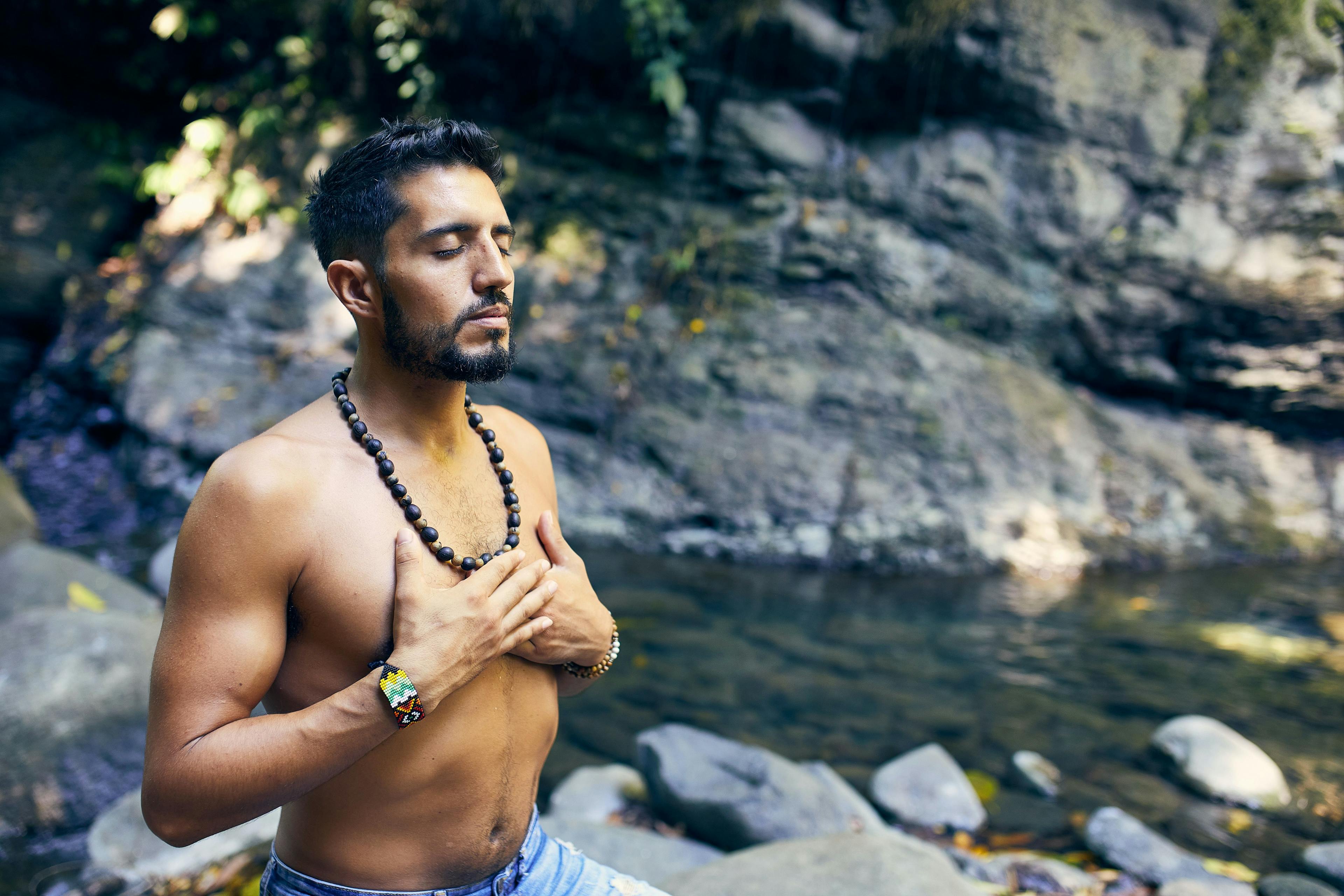 Man meditating near waterfall in Costa Rica.