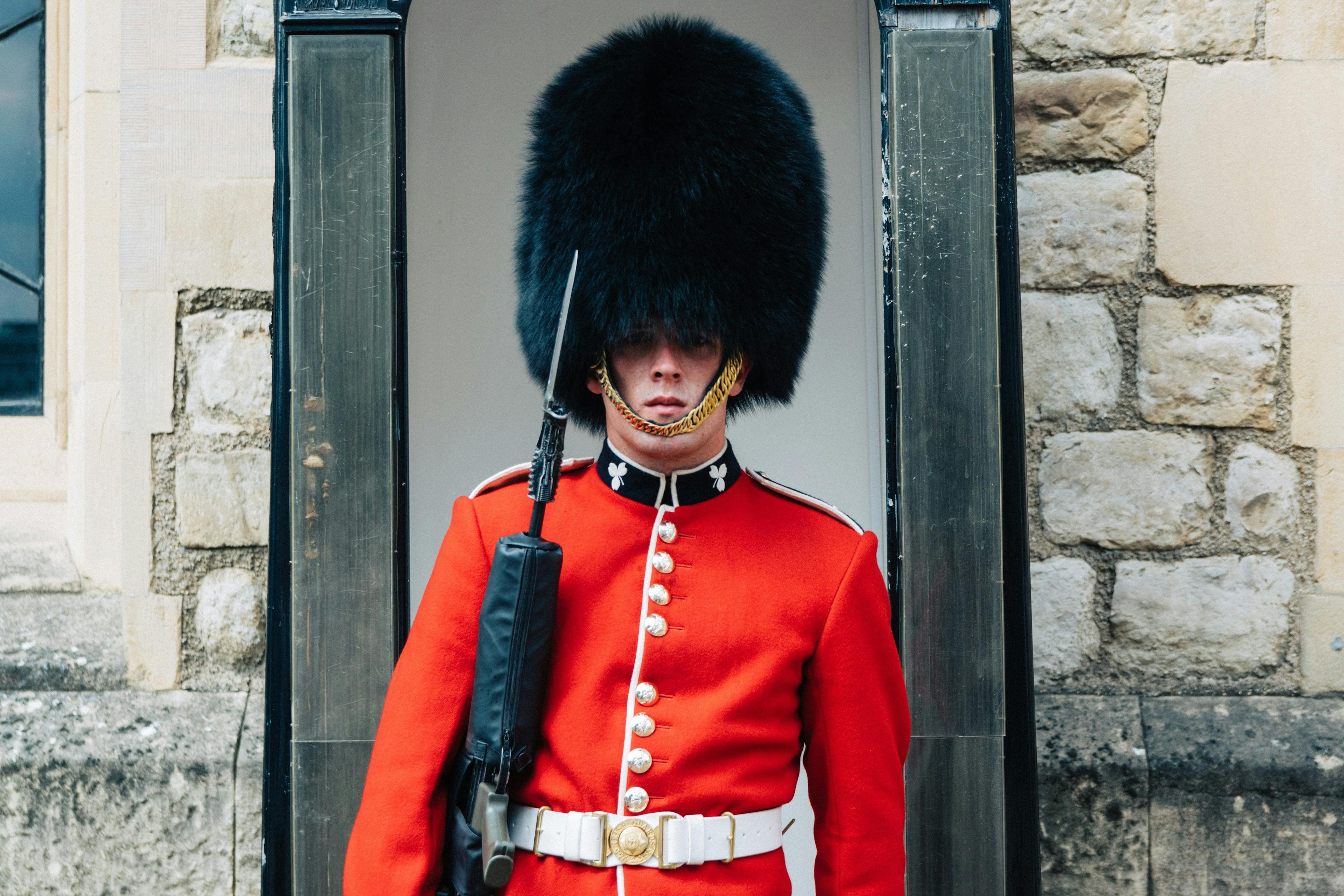 British beefeater standing next to a wall