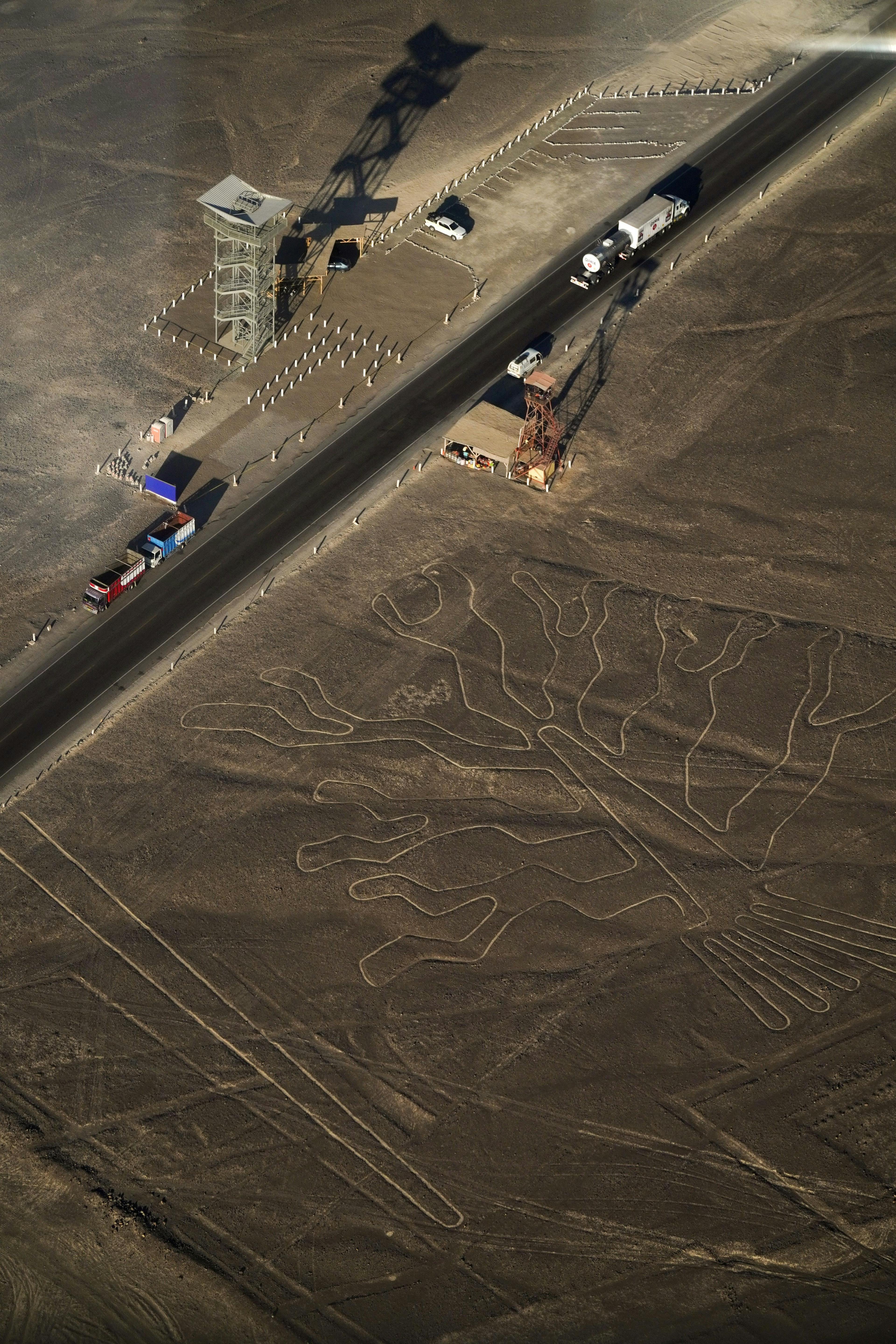 Cars and people next to Nazca geoglyphs in Peru.