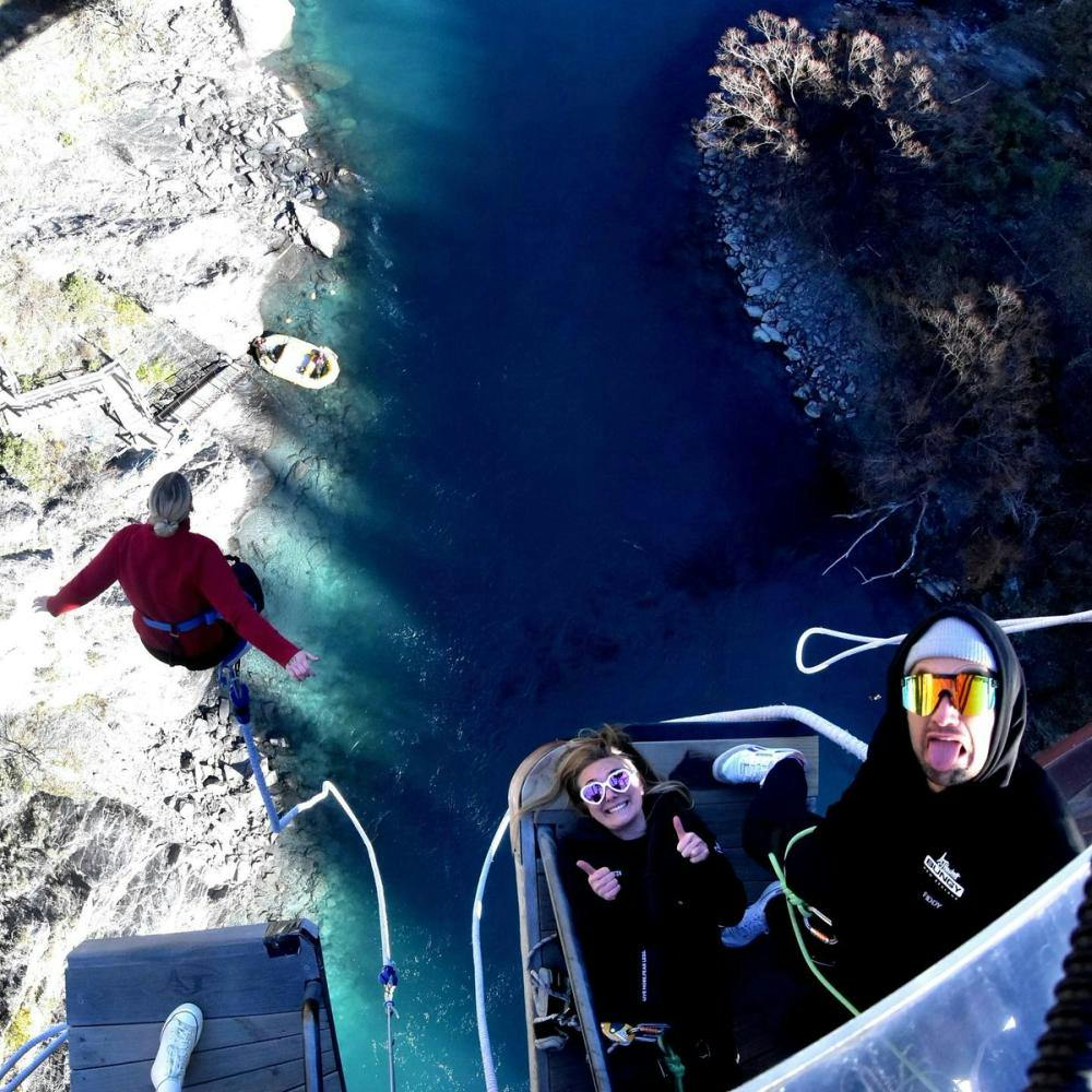 Woman doing bungy jumping above river.