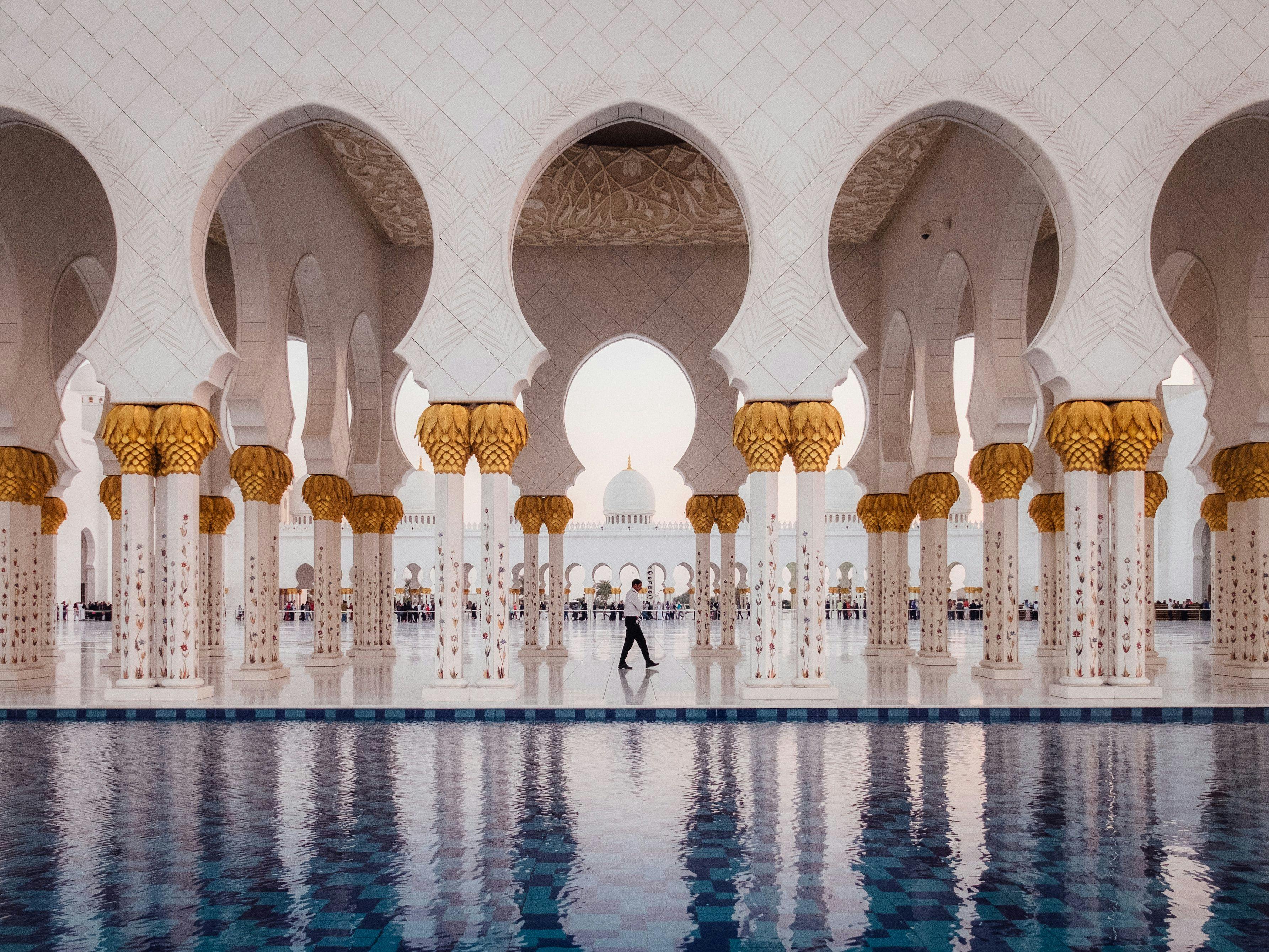 Man walking in Sheikh Zayed Grand Mosque in Abu Dhabi, United Arab Emirates.