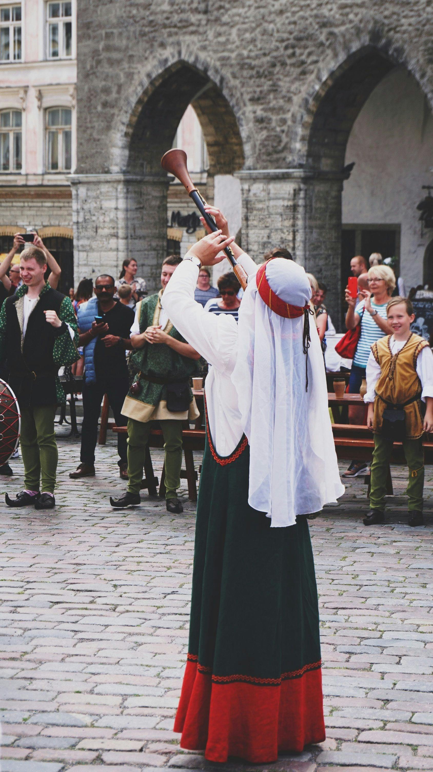 Woman wearing medieval costume playing music in Tallinn.