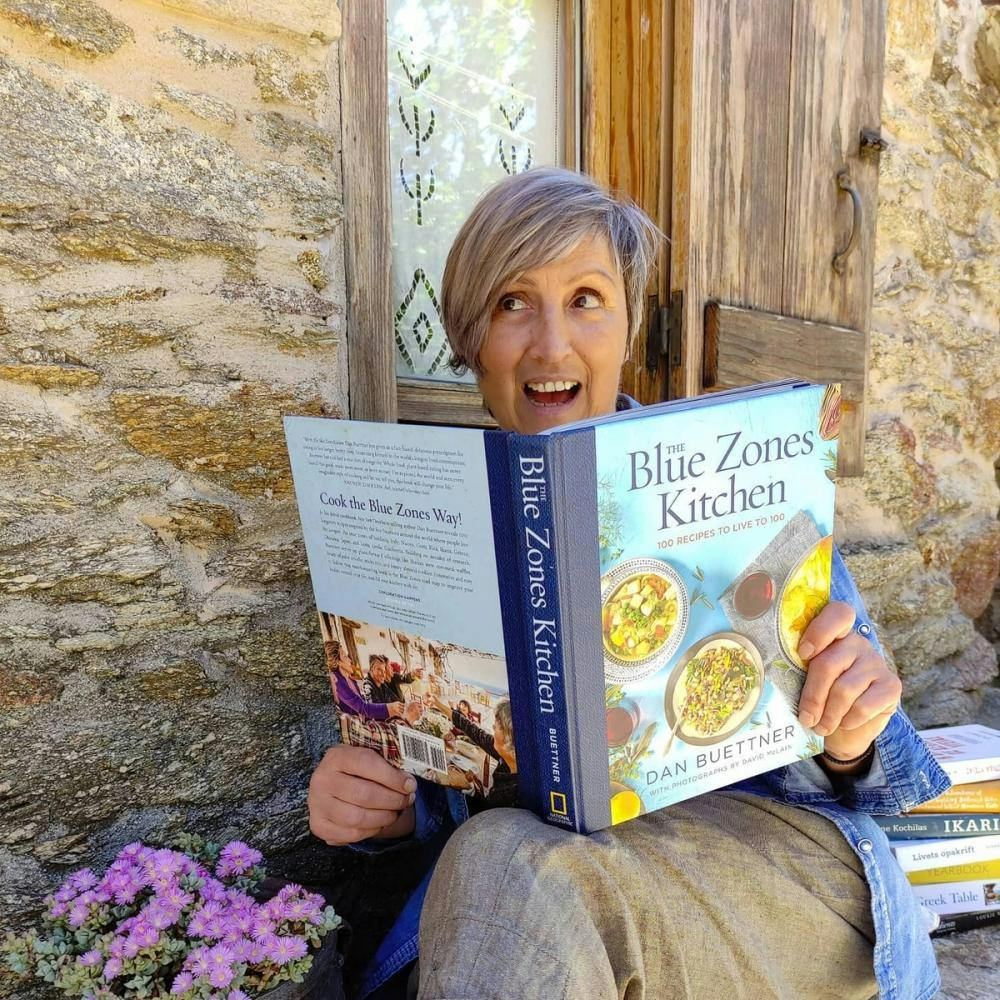 Woman reading cooking book about Blue Zones Kitchen